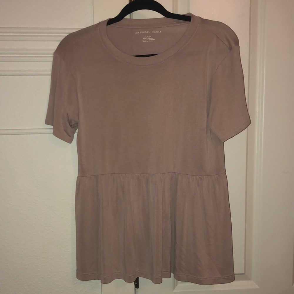 An American Eagle top with ruffles on the bottom. Tan color. Size Small